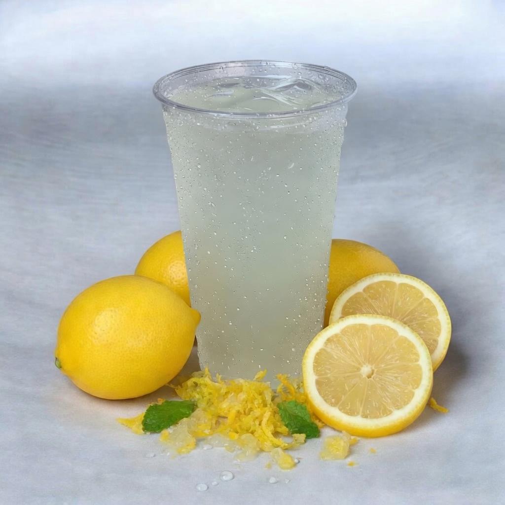 A cup of lemonade with lemons, zest, and mint